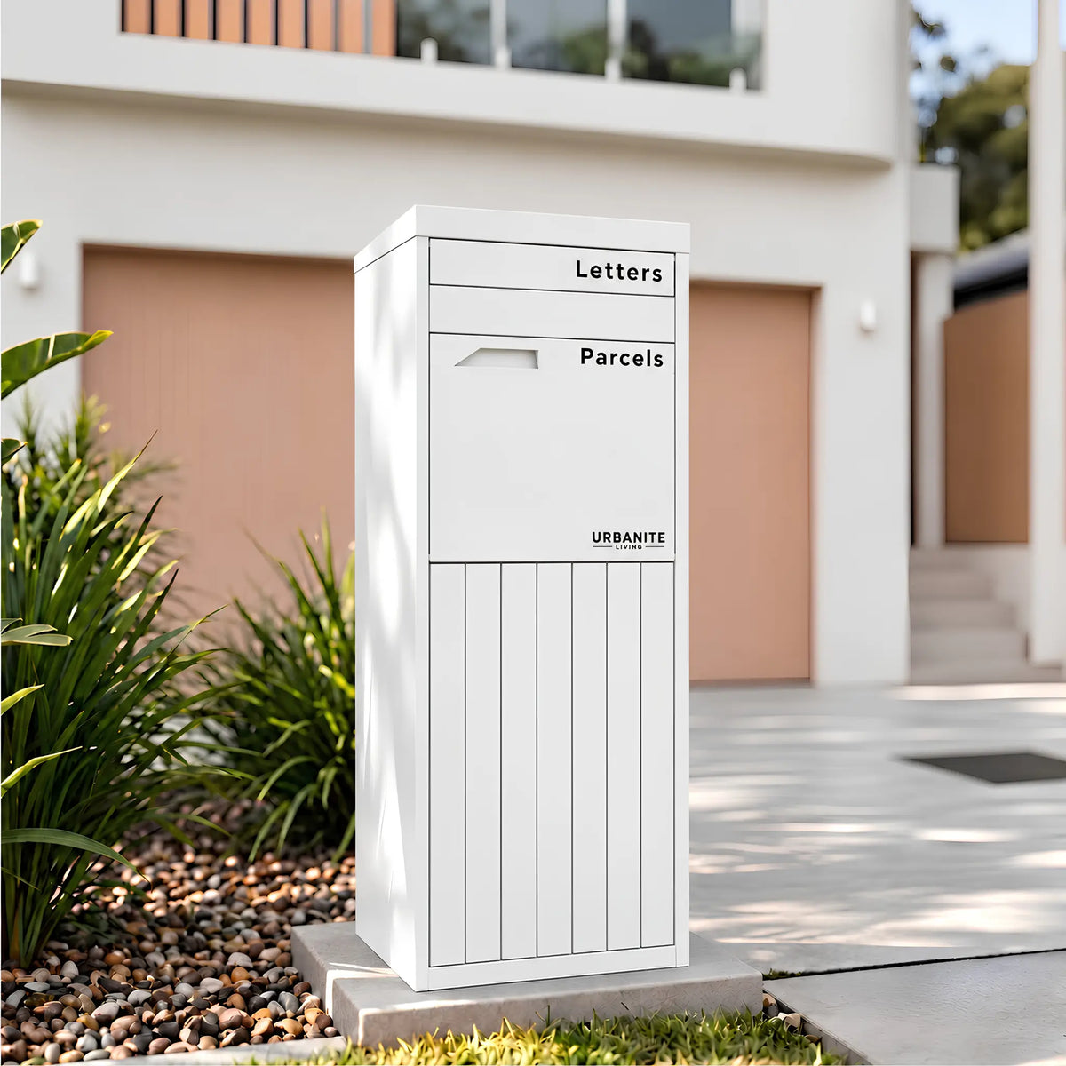 Urbanite Living Corella Extra Tall freestanding parcel letterbox in white beside a driveway at a home.