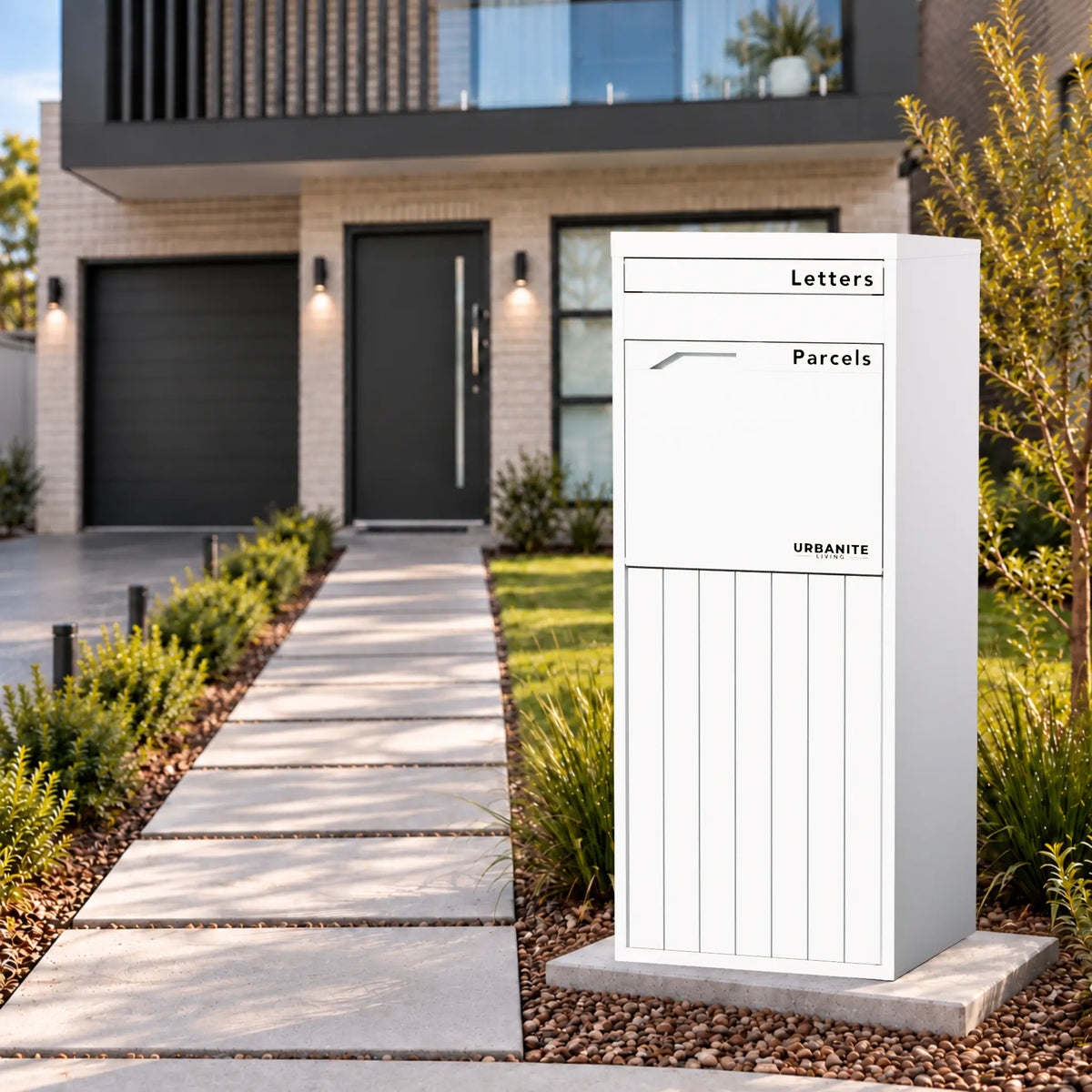 Urbanite Living Corella Extra Tall freestanding parcel letterbox in white beside a front path at a home.