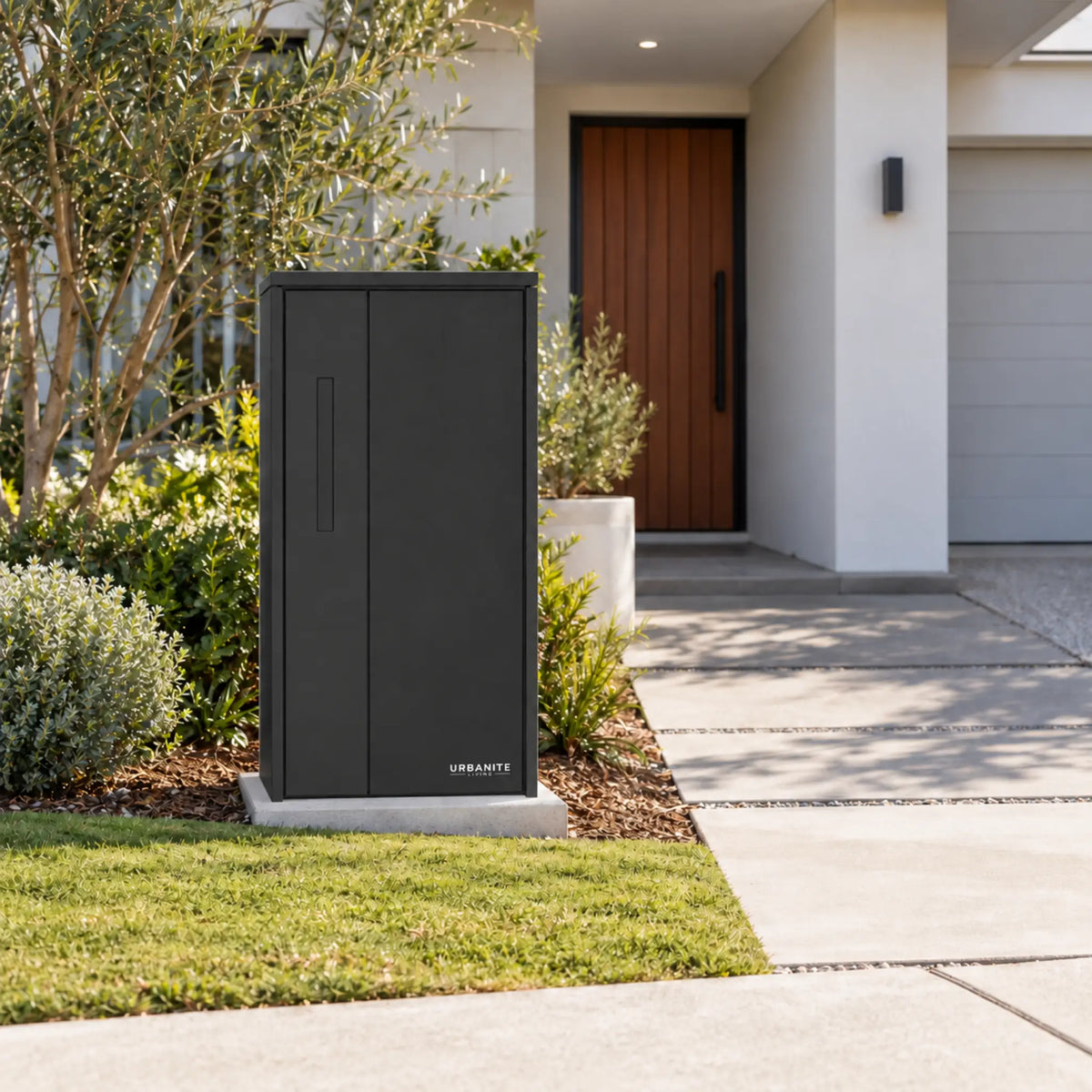 Urbanite Living The Don Extra Wide Parcel Letterbox in black beside a landscaped front path. 
