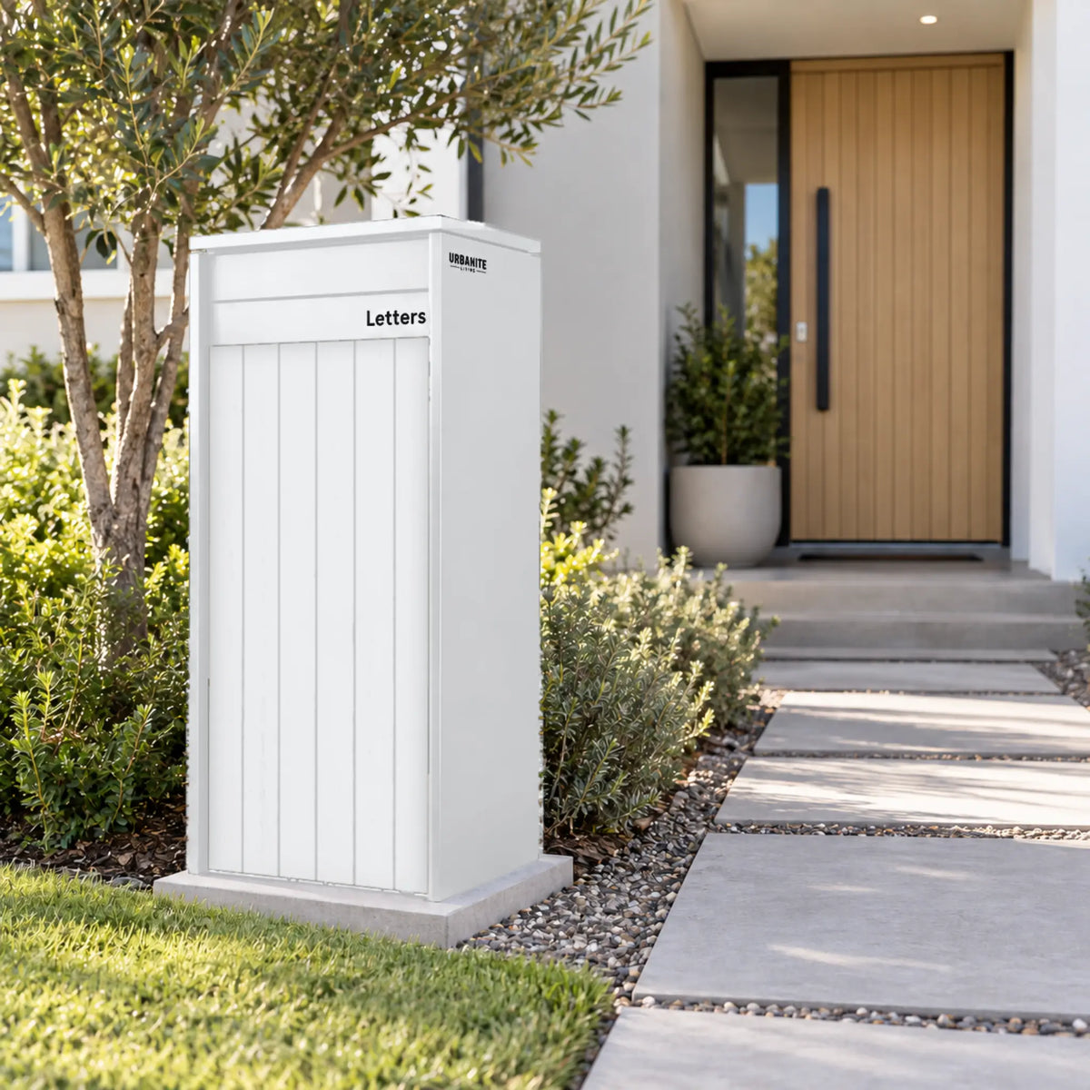 Urbanite Living Heron Extra Wide freestanding parcel letterbox in a white finish beside a garden path.