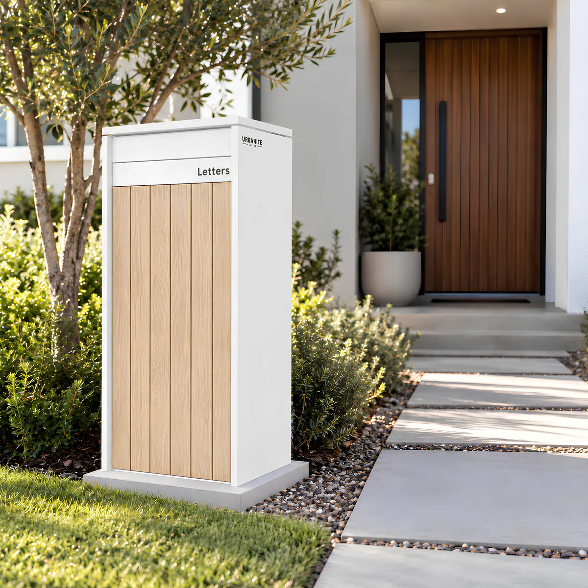Urbanite Living Heron Extra Wide freestanding parcel letterbox in white with light wood look front panels beside a garden path.