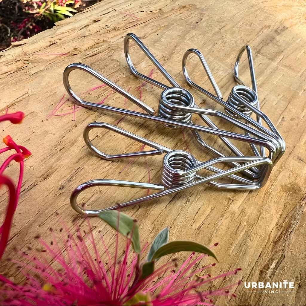 Three marine grade 316 stainless steel pegs. 1 large 2 regular size on a timber post with a grevillea loopy loo and  candy burst bottle brush flowers - brand is Urbanite Living.
