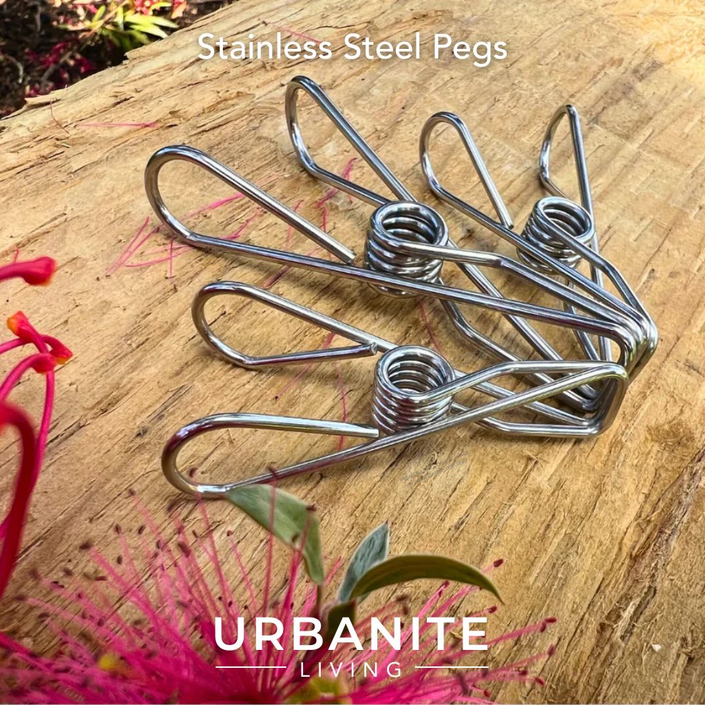 Three marine grade 316 stainless steel pegs. 1 large 2 regular size on a timber post with a grevillea loopy loo and  candy burst bottle brush flowers - brand is Urbanite Living.